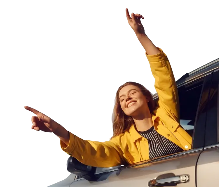 Moteris geltona striuke šypsosi iškišusi rankas pro automobilio langą